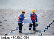 Photovoltaic engineers work on floating photovoltaics. Inspect and repair the solar panel equipment floating on the water. Стоковое фото, агентство Ingram Publishing / Фотобанк Лори