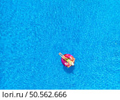 Aerial view of young woman on swimming ring in pool near ocean on summer sunny day. Top drone view of beautiful girl, blue water. Pwani Mchangani, Zanzibar. Travel background. Tropical landscape. Стоковое фото, агентство Ingram Publishing / Фотобанк Лори