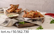 Indian samosas  - fried or baked pastry with savoury filling, popular Indian snacks, served in areca leaf dishes with spices on kitchen countertop. Стоковое фото, агентство Ingram Publishing / Фотобанк Лори