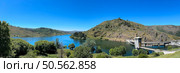 Panoramic view of a tranquil lake nestled among lush hills, under a vast, clear blue sky. Guarda, Portugal. Стоковое фото, агентство Ingram Publishing / Фотобанк Лори