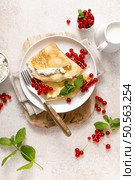 Crepes or thin pancakes with cheese cottage or curd and fresh red currant berries, top view. Стоковое фото, агентство Ingram Publishing / Фотобанк Лори