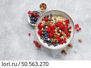 Muesli with organic berries and nuts. Oat muesli with raspberry, blueberry, red currant, almond, pecan, walnut, cashew, hazelnut and pumpkin seeds. Healthy food, top view. Стоковое фото, агентство Ingram Publishing / Фотобанк Лори