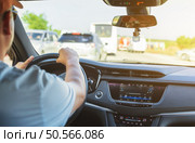Men’s hand holding steering wheel of car while driving. . Стоковое фото, агентство Ingram Publishing / Фотобанк Лори
