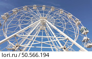A towering white ferris wheel stands tall against a vibrant blue sky, promising exciting views and thrilling rides. Стоковое фото, агентство Ingram Publishing / Фотобанк Лори