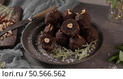 Dark chocolate truffles with hazelnuts and chopped hazelnuts over wooden cutting board. Стоковое фото, агентство Ingram Publishing / Фотобанк Лори