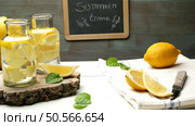 Lemon and lime slices in jars and straws in summer wooden background. Стоковое фото, агентство Ingram Publishing / Фотобанк Лори