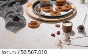 Caramel cookies with pecan nuts served on roud plates, in the kitchen after baking. Стоковое фото, агентство Ingram Publishing / Фотобанк Лори