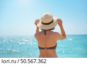 Young woman looking on the sea in hat at day. Relax and nature scene. Стоковое фото, агентство Ingram Publishing / Фотобанк Лори