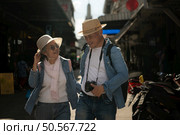 Elderly couples and their activities on the road at the end of the alley where there is a pagoda of Wat Arun, Thailand. Стоковое фото, агентство Ingram Publishing / Фотобанк Лори