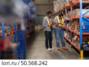 A group of warehouse employees, Inspecting products on warehouse shelves before they are sent to retailer. Стоковое фото, агентство Ingram Publishing / Фотобанк Лори