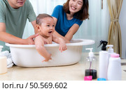 Parents bathe little child after ate meal. Стоковое фото, агентство Ingram Publishing / Фотобанк Лори
