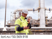 Petroleum engineer is on a mission to inspect oil distillation at a huge oil refinery. Стоковое фото, агентство Ingram Publishing / Фотобанк Лори