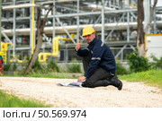 Petroleum engineer is on a mission to inspect oil distillation at a huge oil refinery. Стоковое фото, агентство Ingram Publishing / Фотобанк Лори
