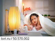 Asian young woman on the bed in the bedroom trying to wake up and prepare for work. Стоковое фото, агентство Ingram Publishing / Фотобанк Лори