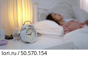 Asian young woman on the bed in the bedroom trying to wake up and prepare for work. Стоковое фото, агентство Ingram Publishing / Фотобанк Лори