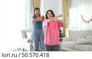 Two sister enjoys dancing together at home during the holidays. Стоковое фото, агентство Ingram Publishing / Фотобанк Лори
