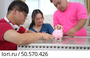 Three siblings save money by putting it in a piggy bank, This is an activity that parents teach their children about saving money. Стоковое фото, агентство Ingram Publishing / Фотобанк Лори