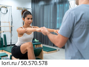 A young man and a young woman are doing pilates exercises on a pilates reformer. Стоковое фото, агентство Ingram Publishing / Фотобанк Лори