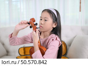 A girl violinist sets up and tunes a violin. Стоковое фото, агентство Ingram Publishing / Фотобанк Лори