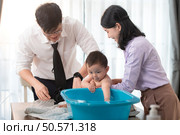 Father and mother bathe their son after they come home from work. Стоковое фото, агентство Ingram Publishing / Фотобанк Лори