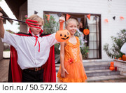 Children in ghost costumes are having fun trick-or-treating on Halloween. Стоковое фото, агентство Ingram Publishing / Фотобанк Лори