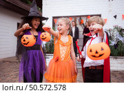 Children in ghost costumes are having fun trick-or-treating on Halloween. Стоковое фото, агентство Ingram Publishing / Фотобанк Лори