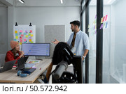 Multiethnic startup business team on meeting in modern bright office interior brainstorming, working on laptop and tablet computer. Стоковое фото, агентство Ingram Publishing / Фотобанк Лори