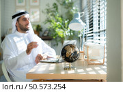 Portrait of young Arabic businessman working on laptop at home. Стоковое фото, агентство Ingram Publishing / Фотобанк Лори