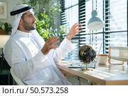 Portrait of young Arabic businessman working on laptop at home. Стоковое фото, агентство Ingram Publishing / Фотобанк Лори