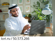 Portrait of young Arabic businessman working on laptop at home. Стоковое фото, агентство Ingram Publishing / Фотобанк Лори
