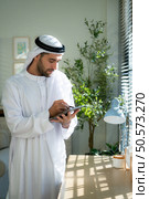 Portrait of young Arabic businessman working on laptop at home. Стоковое фото, агентство Ingram Publishing / Фотобанк Лори