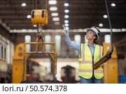 Portrait of railway technician worker in safety vest and helmet working at train repair station. Стоковое фото, агентство Ingram Publishing / Фотобанк Лори