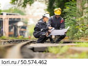 Railway technicians and engineers, Working on the train tracks at train station. Стоковое фото, агентство Ingram Publishing / Фотобанк Лори