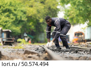 Portrait of a railway engineer on the tracks of a train in station platform. Стоковое фото, агентство Ingram Publishing / Фотобанк Лори