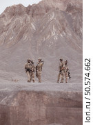 Soldiers in camouflage military uniforms carrying weapons, Reconnaissance missions in rugged mountains, Assault infantry battle training. Стоковое фото, агентство Ingram Publishing / Фотобанк Лори
