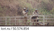 Soldiers in camouflage military uniforms carrying weapons, Reconnaissance missions in the tropical forest area, Assault infantry battle training. Стоковое фото, агентство Ingram Publishing / Фотобанк Лори