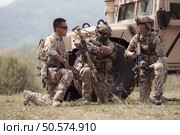 Group of soldiers in camouflage uniforms hold weapons in a jltv car, Plan and prepare for combat training. Стоковое фото, агентство Ingram Publishing / Фотобанк Лори