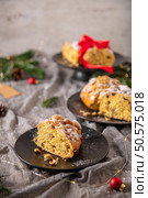 A tempting slice of Bolo Rainha, a Portuguese Christmas cake, is displayed. It’s studded with nuts and candied fruit, dusted with powdered sugar, inviting a festive indulgence. Стоковое фото, агентство Ingram Publishing / Фотобанк Лори