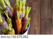 Fresh organic rainbow carrots in a bucket on a wooden table. Стоковое фото, агентство Ingram Publishing / Фотобанк Лори