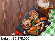 Grilled sausages and beer mug on wooden table. Top view with copy space. Стоковое фото, агентство Ingram Publishing / Фотобанк Лори