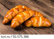 Tasty croissants with spikelets on grey wooden background. Стоковое фото, агентство Ingram Publishing / Фотобанк Лори