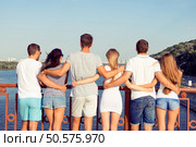 at summer holidays group of friendly students hugging on city embankment. Стоковое фото, агентство Ingram Publishing / Фотобанк Лори