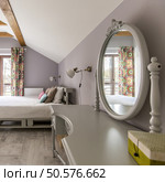 Spacious grey bedroom with a king-size pallete bed and mirror. Стоковое фото, агентство Ingram Publishing / Фотобанк Лори