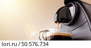 Espresso machine making coffee in a glass cup and beige gradient background. Low level, panoramic view. Стоковое фото, агентство Ingram Publishing / Фотобанк Лори