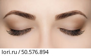 Beautiful Woman with long lashes in a beauty salon. Eyelash extension procedure. Стоковое фото, агентство Ingram Publishing / Фотобанк Лори