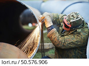 Construction Welder worker in protective glasses cutting metal pipe at building site with welding flame torch cutter. Стоковое фото, агентство Ingram Publishing / Фотобанк Лори