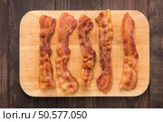 Fried bacon strips on the wooden board. Стоковое фото, агентство Ingram Publishing / Фотобанк Лори