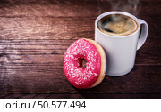 white mug of coffee and a donut on a wooden dark  background. Стоковое фото, агентство Ingram Publishing / Фотобанк Лори