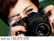 Red-haired girl with green eyes taking pictures camera in the city park. Стоковое фото, агентство Ingram Publishing / Фотобанк Лори
