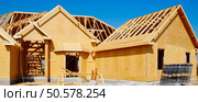 New home under construction with wood, trusses and supplies. Стоковое фото, агентство Ingram Publishing / Фотобанк Лори